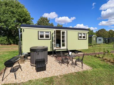 A tiny house with a hot tub and seating area at Magnolia in Grimsby