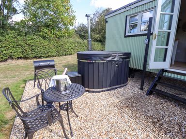 An outdoor area with a hot tub and seating at Snowdrop in Grimsby