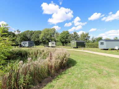 Huts on a grassy area with a pathway at Snowdrop in Grimsby