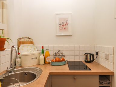 A kitchen counter with a sink kettle croissants and juice at The Dairy at Wyke Farm in Wyke near Lyme Regis
