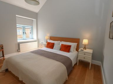 A bedroom with a double bed two bedside tables with lamps and a window at Stapleford Farm in Hooke near Beaminster