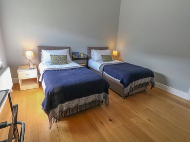 A bedroom with two single beds bedside tables and lamps at Stapleford Farm in Hooke near Beaminster