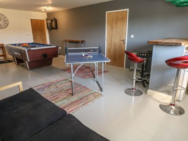 A game room with a pool table table tennis table bar stools and a dartboard at Stapleford Farm Hooke near Beaminster