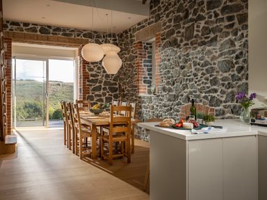 A kitchen with a dining table and chairs at Trevean in Mullion