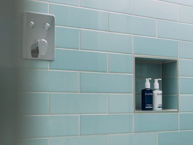 A bathroom with blue tiles and soap dispensers at Trevean in Mullion