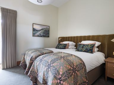 A bedroom with twin beds and a bedside table at Trevean in Mullion