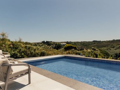 An outdoor area with a swimming pool and lounge chairs at Trevean in Mullion