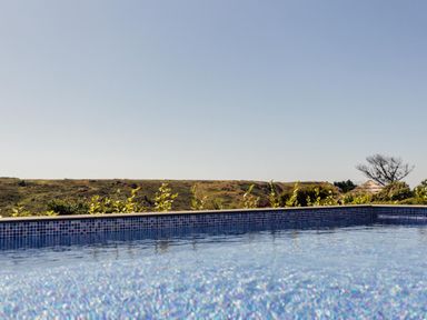 A swimming pool with water and landscape at Trevean in Mullion