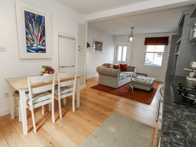 A kitchen with a dining table and seating at Fisherman’s Cottage 