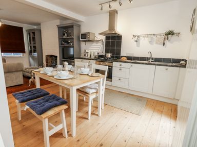 A kitchen with a dining table and chairs at Fisherman’s Cottage in 