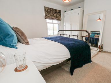 A bedroom with a bed and wardrobe at Fisherman’s Cottage