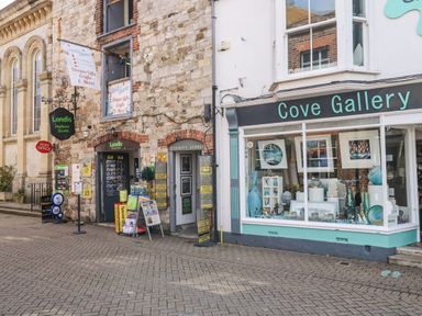 Outdoor view of storefronts including Londis Harbour Store and Cove Gallery at Fisherman’s Cottage