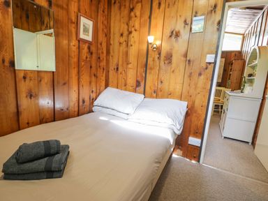 A bedroom with a bed and a mirror at Ty Bedwen in Dinas Mawddwy