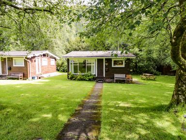 A cabin with a pathway and picnic table at Ty Bedwen in Dinas Mawddwy