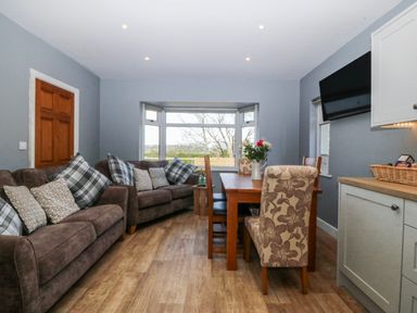 A dining room with a sofa and dining table at Tirionfa in Talsarnau