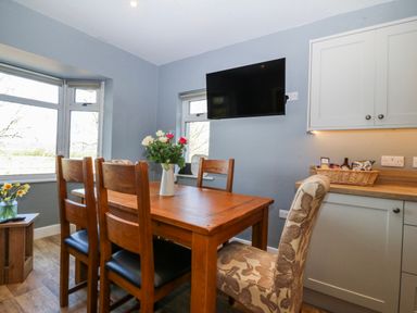 A dining room with a table and chairs at Tirionfa in Talsarnau