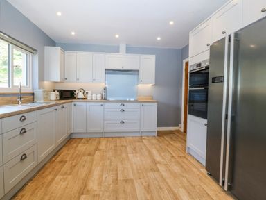 A kitchen with cabinets and appliances at Tirionfa in Talsarnau