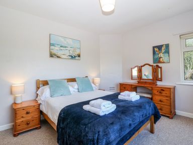 A bedroom with a bed and a dresser at Tirionfa in Talsarnau