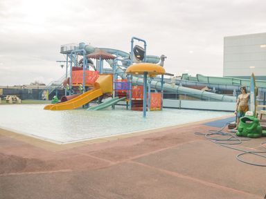 A water play area with slides and a shallow pool with statues at Summerdown in Brean