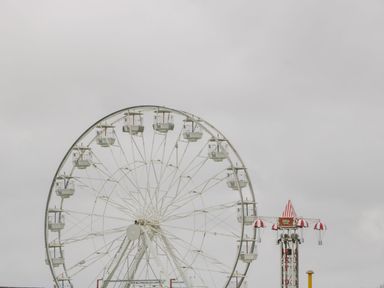 A ferris wheel and a parachute drop ride in an amusement park at Summerdown in Brean