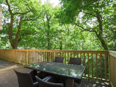 An outdoor area with a table and chairs at Lodge 68 - Fern Gully near Finlakes Holiday Park near Chudleigh
