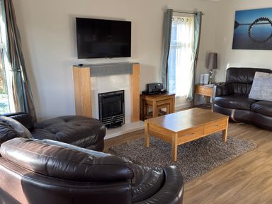 A living room with a fireplace and television at Woodland View 31 - The Hawthorns near Chudleigh