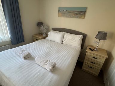 A bedroom with a double bed and two towels at Woodland View 31 - The Hawthorns Finlakes Holiday Park near Chudleigh