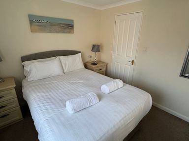 A bedroom with a bed and nightstand at Woodland View 31 - The Hawthorns near Finlakes Holiday Park