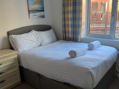 A bedroom with a bed and towels at Woodland View 31 - The Hawthorns Finlakes Holiday Park near Chudleigh