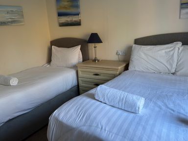 A bedroom with two beds and a nightstand at Woodland View 31 - The Hawthorns Finlakes Holiday Park near Chudleigh