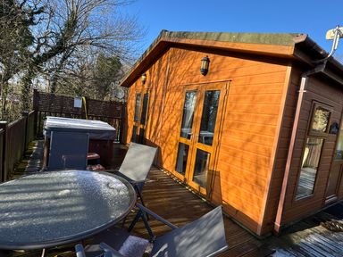An outdoor area with a hot tub and seating at Woodland View 31 - The Hawthorns near Finlakes Holiday Park