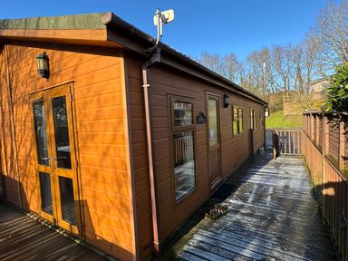 An exterior wooden building with a deck at Woodland View 31 - The Hawthorns Finlakes Holiday Park near Chudleigh