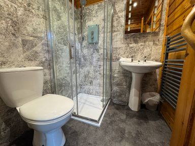 A bathroom with a shower and toilet at Tor View in Finlakes Holiday Park near Chudleigh