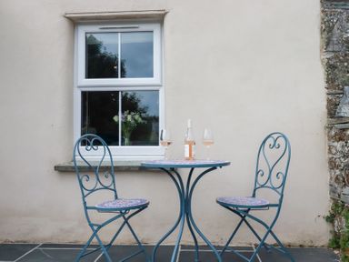 A table with two chairs and wine glasses at Glendale, Port Isaac