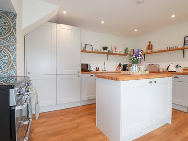 A kitchen featuring a stove, sink, and wooden kitchen island at Glendale in Port Isaac