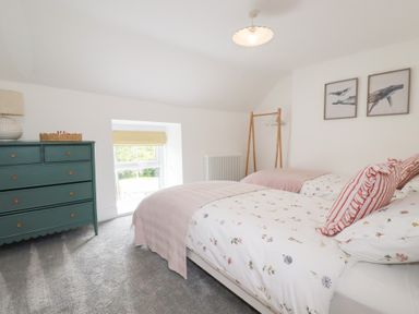 A bedroom with two beds and a dresser at Glendale in Port Isaac