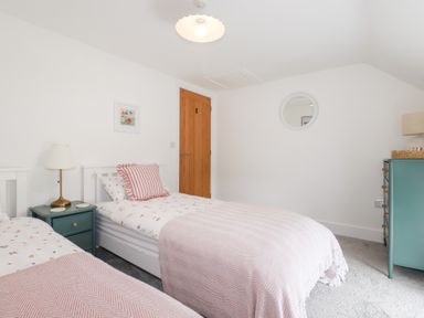 A bedroom with twin beds and a nightstand at Glendale in Port Isaac