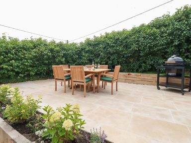 A garden with a dining table and grill at Glendale in Port Isaac