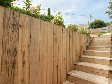 A wooden staircase with a fence and plants at Glendale in Port Isaac