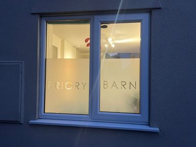 A window with frosted glass and the words Priory Barn on it at Priory Barn Apartment in Walton near Street