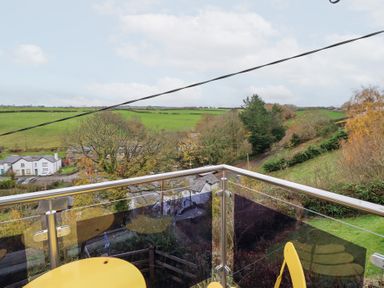 A balcony view overlooking fields and trees at Golygfa Pandy Tudur near Llanrwst