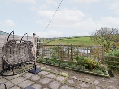 A garden with a swing chair and plants at Golygfa Pandy Tudur near Llanrwst