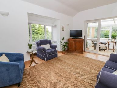 A living room with sofas and a television at Llain in Cardigan