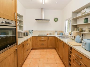 A kitchen with cabinets and appliances at Llain in Cardigan