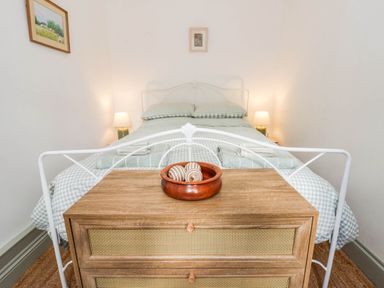 A bedroom with a bed and dresser at Llain in Cardigan