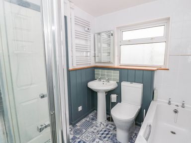 A bathroom with shower, sink, toilet, and bathtub at Llain in Cardigan