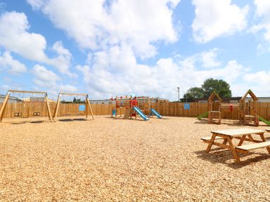 An outdoor play area with swings and slides at 440 California Sands