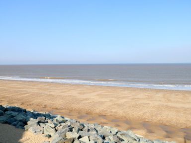 A beach view with sand and rocks at 440 California Sands