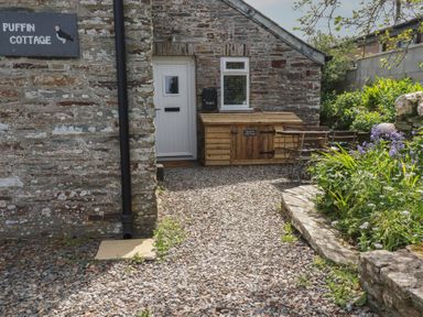 An outdoor area with a door and seating at Puffin Cottage in Tintagel