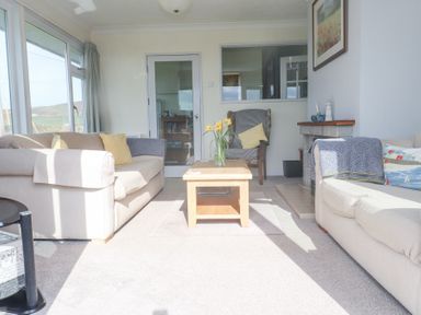 A living room with two sofas a wooden coffee table and a chair at Seafield in Rhydwyn near Cemaes Bay